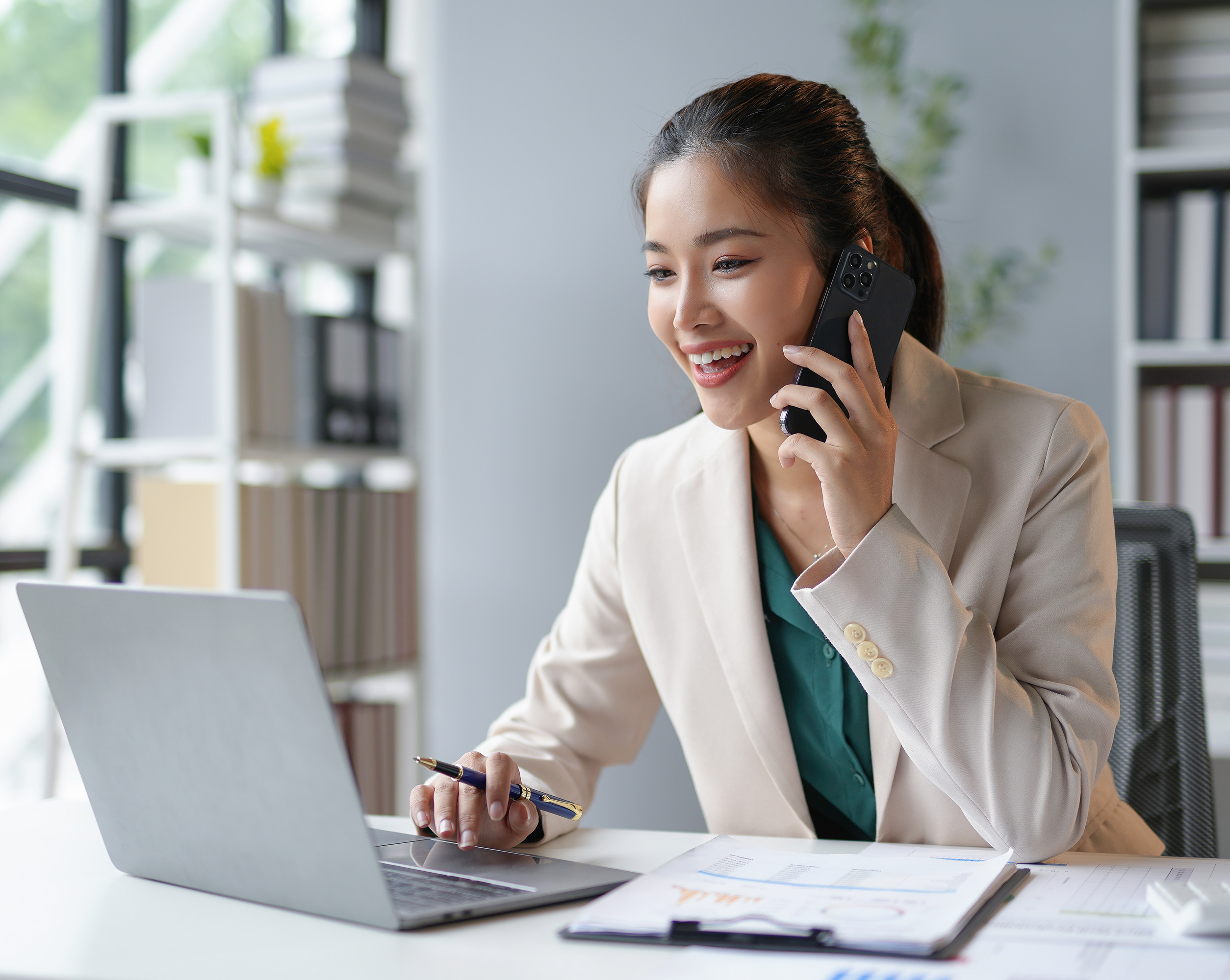 A smartly dressed woman on the phone and working on laptop talking about the major workforce reforms ahead for Hong Kong in 2025. With the long-anticipated launch of the eMPF platform to updates in employment laws and an increase in minimum wage - there is a lot for employers and employees to prepare for.