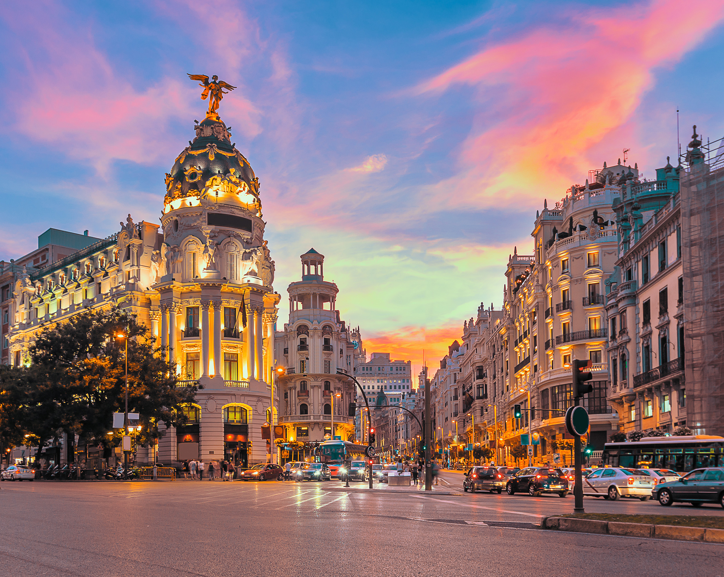 A beautiful sunset in Spain's capital Madrid, compromising of pink, blue, yellow and orange tones in the sky and clouds with grand architecture building.

It's a very attractive place for expats, especially with the tax regime.