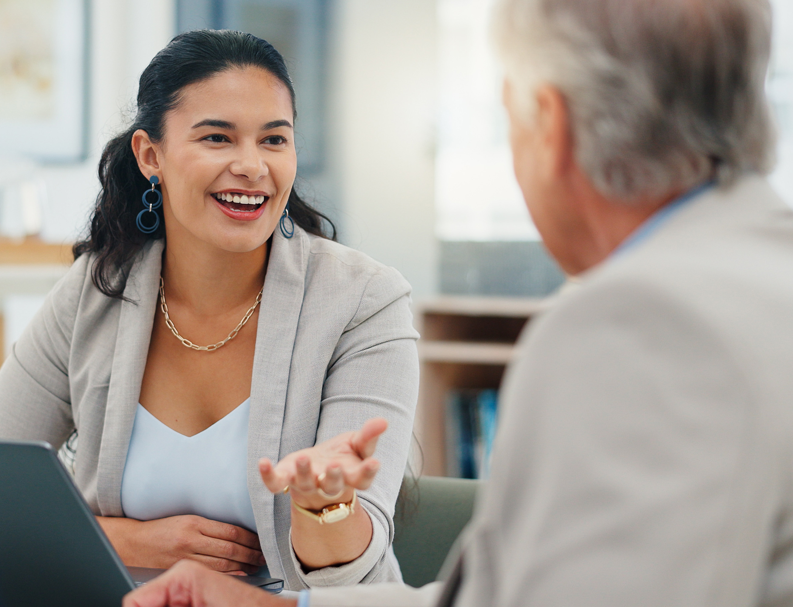 A smartly dressed lady explaining employee benefits to a client. NHS delays are costing businesses. Learn why timely employee healthcare is vital for retention, productivity, and business sustainability in 2025.