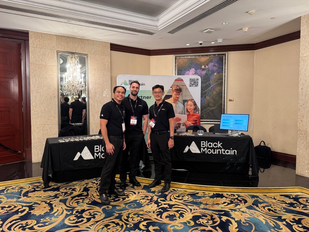 Jonathan Ganesh on the left, Luca Pope in the middle, and Yu-Jin Lau on the right, all wearing Black Mountain polos stood in front our stall at the 2025 Singapore Business Federation Conference. 