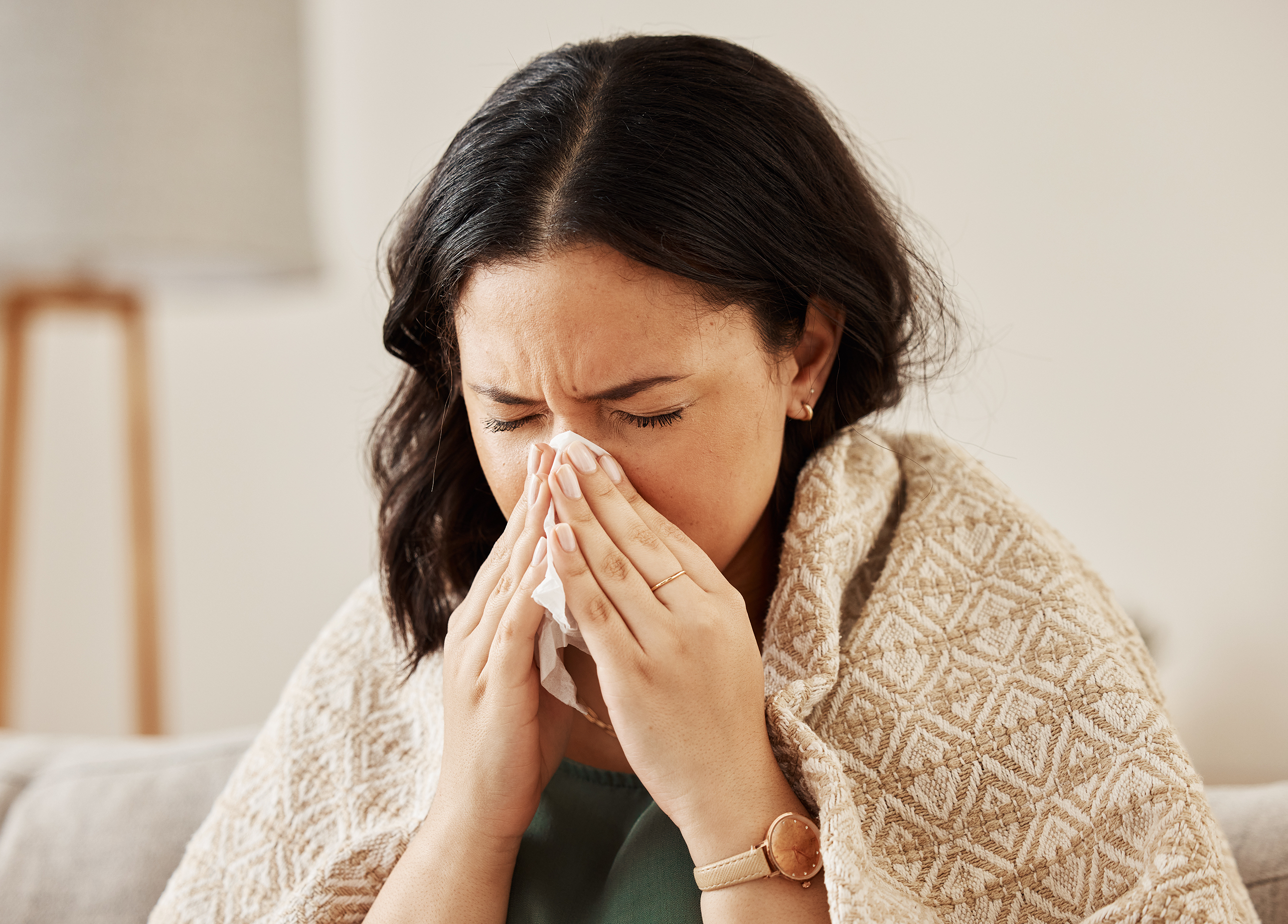 2026 Employment Law Changes are impacting sick pay which is now from day one. This image shows an employee sick blowing her nose.